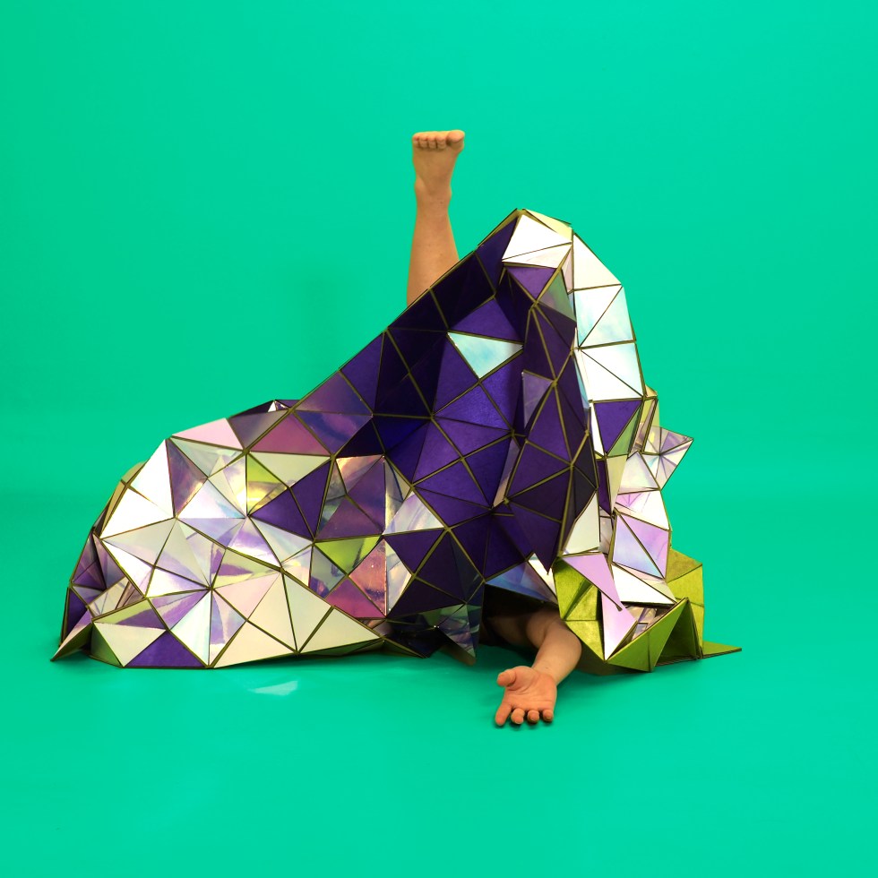 A geodesic tapestry made of mirror triangles and purple fabric, with Lucy Fandel's foot and arm visible.